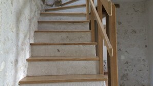 A staircase with wooden handrails and a white wall. - Le Colombier Guesthouse (Concriers)