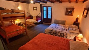 Une chambre confortable avec des lits superposés, un lit simple, un bureau et une chaise.