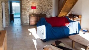 A cozy living room with a stone wall, a wooden staircase, and a red lamp. - Fisherman's house Gulf of Morbihan (Sarzeau)