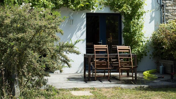 A white house with a grey roof, a stone chimney, and a wooden door. - Fisherman's house Gulf of Morbihan (Sarzeau)