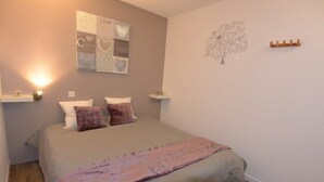 A bedroom with a bed, two bedside tables, a wall art piece, and a decorative tree. - Risoul 4 bedroom duplex sleeps 11, at the foot of the slopes, summer winter (Risoul)