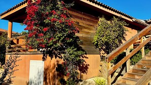 Un edificio con tejado de baldosas, escalera de madera y una puerta.