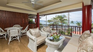 A balcony with wicker furniture, a ceiling fan, and a view of the sea. - ROMANTIC AND DESIGN APARTMENT, PATONG BEACH (PATONG)