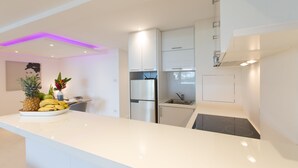 A modern kitchen with white cabinetry, a stainless steel refrigerator, and a built-in stove. - ROMANTIC AND DESIGN APARTMENT, PATONG BEACH (PATONG)
