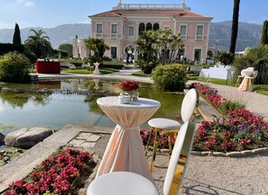 Enjoy a serene atmosphere amidst lush greenery and beautiful flowers in this elegant outdoor space.