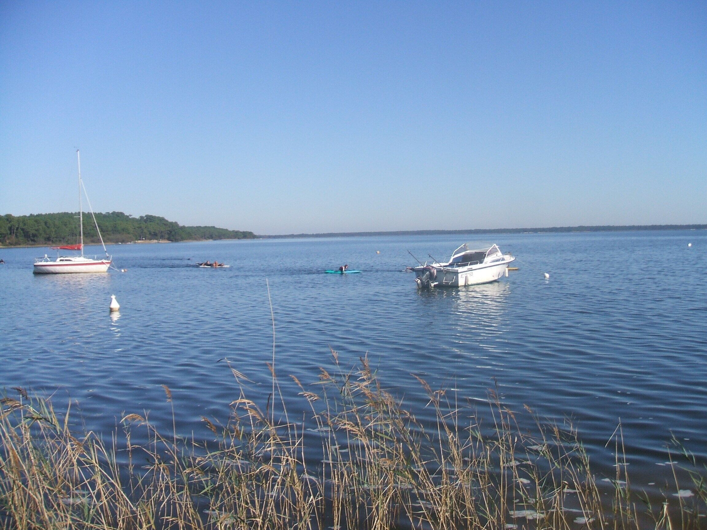 Ein ruhiger See mit mehreren vor Anker liegenden Booten.
