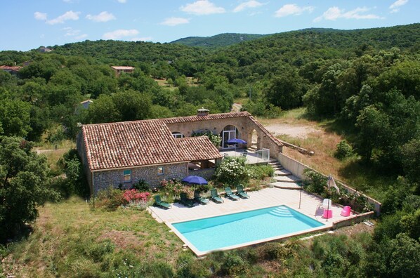 A stone house with a swimming pool, surrounded by lush greenery and hills. - Sheepfold in Languedoc with a private pool (Montoulieu)