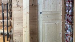 Un interior de madera con una puerta que indica “Salle de Bain” y una cortina estampada.