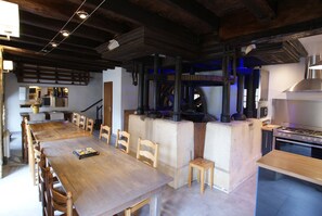 Una cocina rústica con una mesa y sillas de madera, un horno empotrado y un ventanal grande.