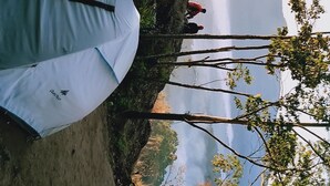 A tent set up on a dirt ground with a view of a mountainous landscape in the background. - Munnar Jungle Camp (Devikolam)