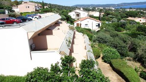 Zona residencial con casas, cielo azul despejado y vista distante del mar.