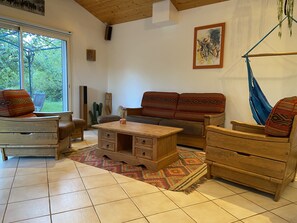 Ein gemütliches Wohnzimmer mit einer Holzsofa, einem Couchtisch aus Holz und einer Hängematte.