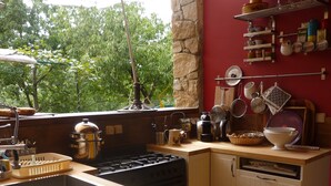 A kitchen with a wooden countertop, a stove, a sink, and a window overlooking greenery. - Beautiful, quiet property with swimming pool, spa and stone outbuilding + air conditioning (Privas)