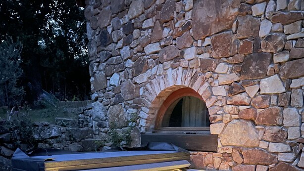 A hot tub with a stone wall backdrop, a wooden bench, and a small step leading up to it. - Beautiful, quiet property with swimming pool, spa and stone outbuilding + air conditioning (Privas)