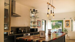 A modern kitchen with a wooden island, built-in appliances, and a hanging light fixture.