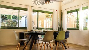 A dining area with a table set for four, surrounded by chairs with wooden legs.