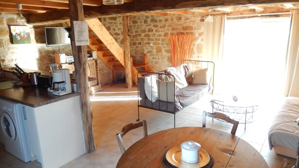 Un interior rústico con cocina, comedor y cama.