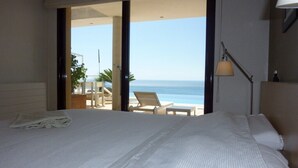 A hotel room with a large bed, a view of the beach, and a balcony with chairs. - Luxury villa near the sea with wonderful sea view, infinity swimming pool, south (Altea)