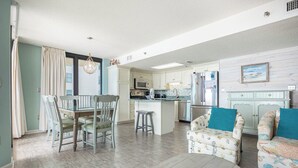 Un salón amplio con comedor, cocina y una pequeña isla.