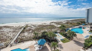 Un complejo turístico frente a la playa con zona de piscina, acceso directo a la costa y un paseo marítimo.