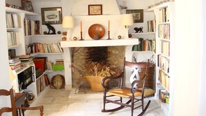 A cozy reading nook with a fireplace, bookshelves, and a rocking chair. - On 2 hectares, air-conditioned Provencal farmhouse in idyllic Provence   (L'isle-Sur-La-Sorgue)