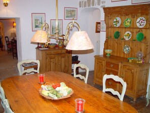 Uma área de refeições com mesa de madeira, cadeiras e aparador.
