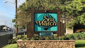 Naamplaatje voor 'Sea Watch' met een logo van een zeegroene en gouden schelp, gelegen op nummer 11500.