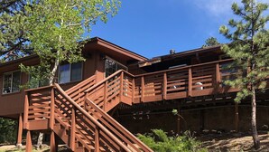A wooden staircase leading to a building with a balcony.