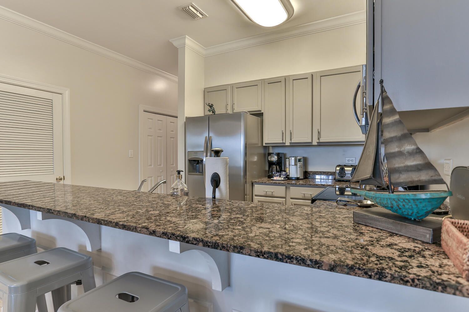 A kitchen with granite countertops, stainless steel appliances, and a unique decorative sail.