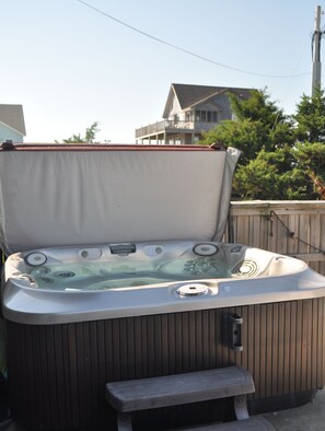 A hot tub with a bench, surrounded by a wooden fence, and a house in the background. - Sweet Sands of Salvo - 6BR/5.5 BATH Luxury Home with Panoramic Views (Salvo)