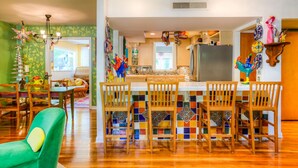 A spacious kitchen with a tiled backsplash, wooden chairs, and a central island. - The CHA CHA CHA is a colorfully decorated home in a desirable neighborhood. (Austin)