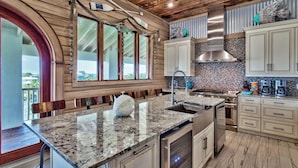 A modern kitchen with granite countertops, stainless steel appliances, and wooden accents.