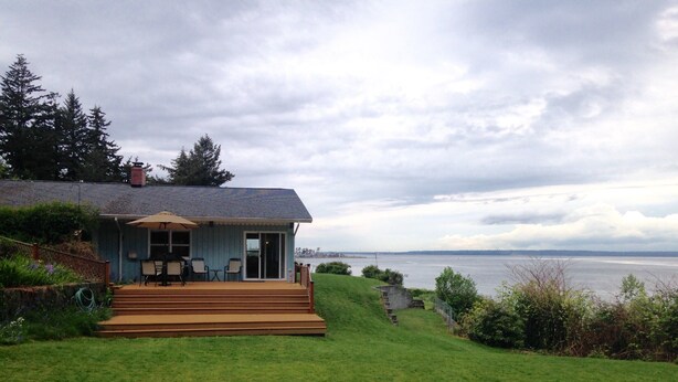 A house with a deck overlooking a body of water.