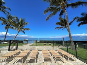 Relax in style with ocean views from this serene patio, featuring comfortable lounge chairs and a tranquil atmosphere.