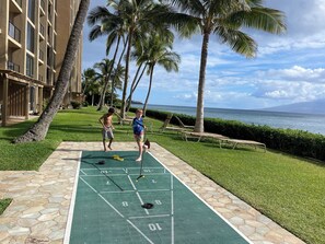 Relax and unwind on the lush lawn, where a shuffleboard court and lounge area await.