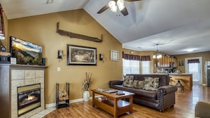 A living room with a fireplace, a sofa, a coffee table, and a television.