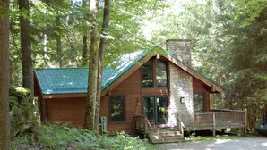 A cabin with a stone chimney, wooden exterior, and a porch. - Dreamcatcher-Harvest Moon Cottages (Rockbridge)