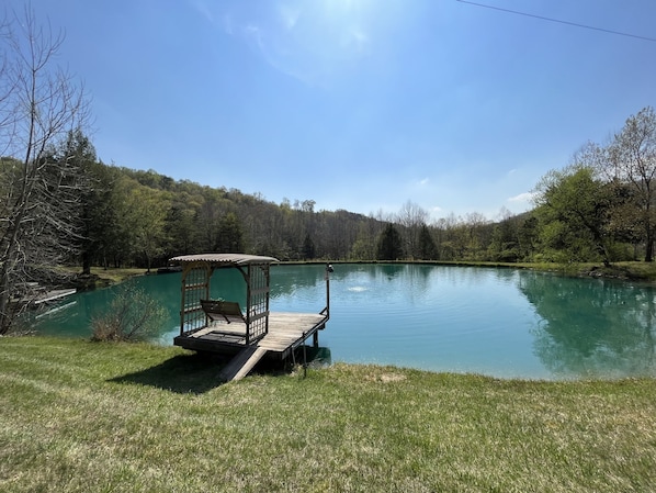 A tranquil lakeside setting with a wooden dock and gazebo.