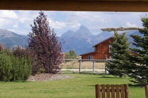 A wooden cabin with a view of mountains in the background.