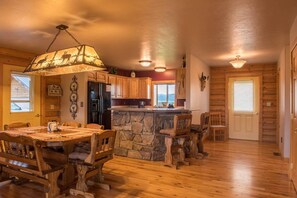 L’intérieur d’une cabine comprenant un bar en pierre, une table à manger en bois et des chaises.