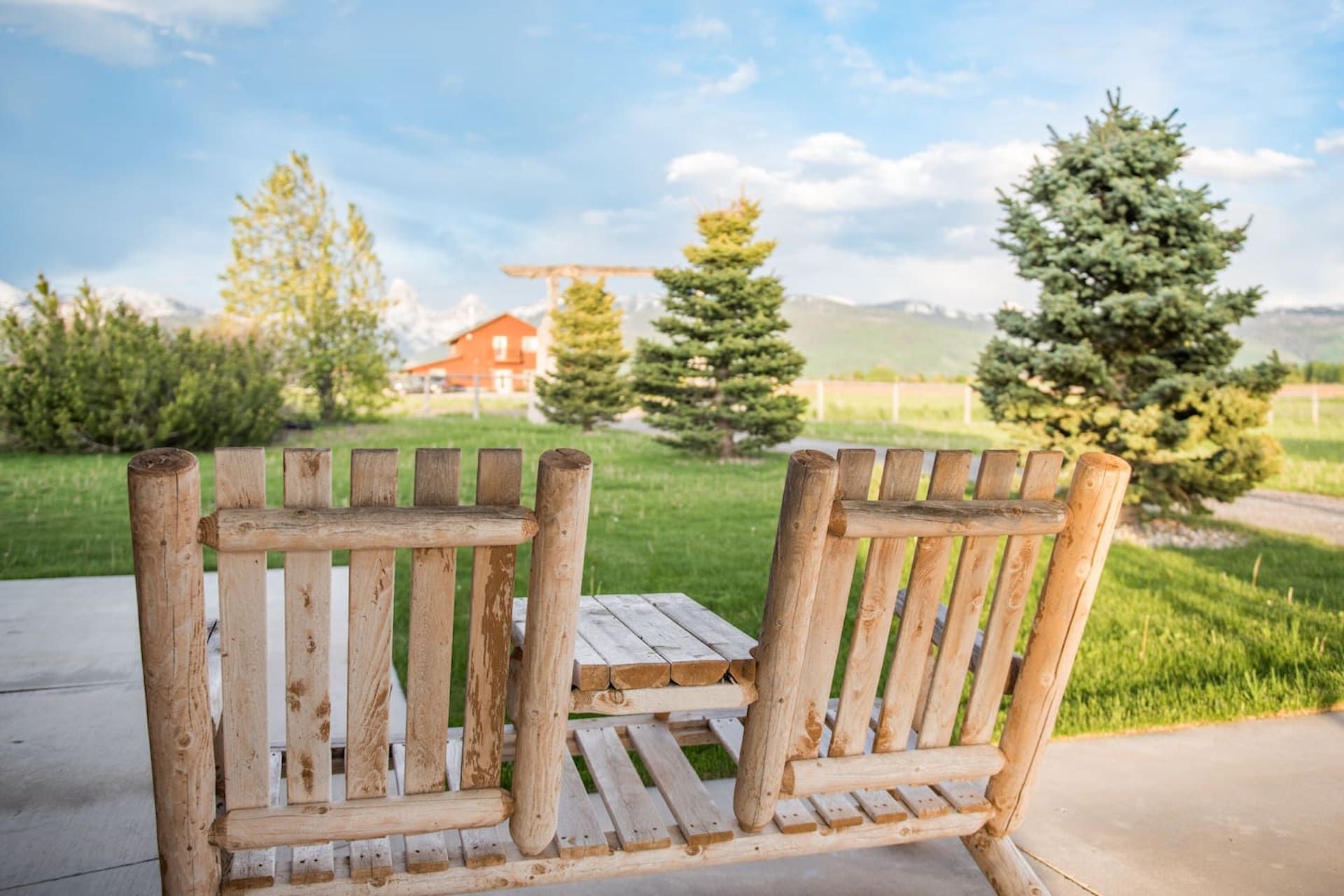 Una panchina di legno con un tavolo in giardino.