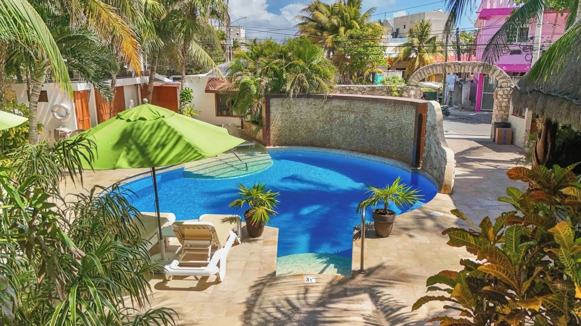 Une piscine avec des chaises longues et des plantes en pot.