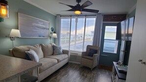 A cozy living area with a sofa, a chair, a dining table, and a ceiling fan. - BEACH TIME!  Ocean side! Private area, no crowds - Steps from sand.  Downstairs. (Atlantic Beach)
