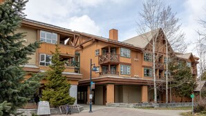 A large wooden building with multiple balconies and a covered entrance. - Mountain Views in Whistler Village (Whistler)
