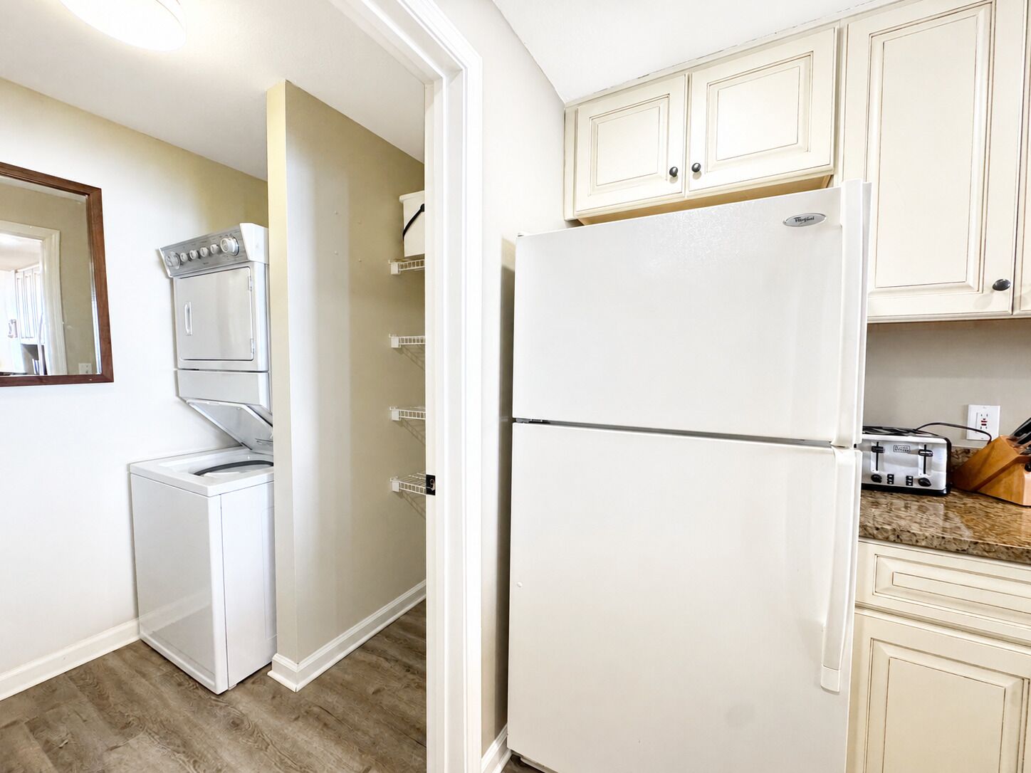 A compact kitchen with a built-in washer, a refrigerator, and a toaster.