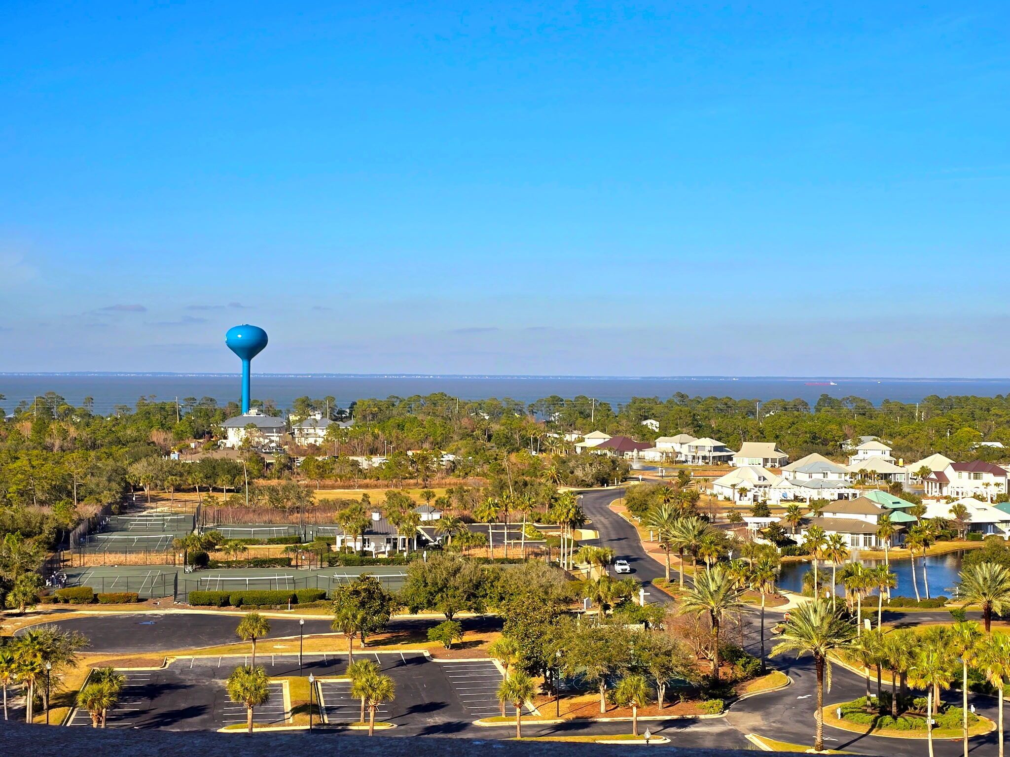A residential area with houses, a water tower, and a tennis court.