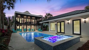 Una casa moderna de dos pisos con piscina y jacuzzi.