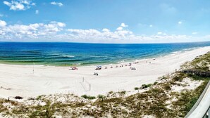 Una spiaggia con vista libera sull'oceano, una riva sabbiosa e alcuni ombrelloni.