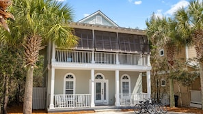 A two-story house with a balcony, a front door, and a garage.