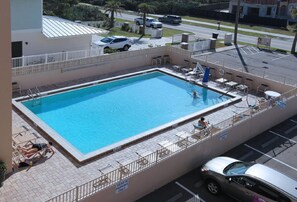 A rooftop swimming pool with a view of the street below.